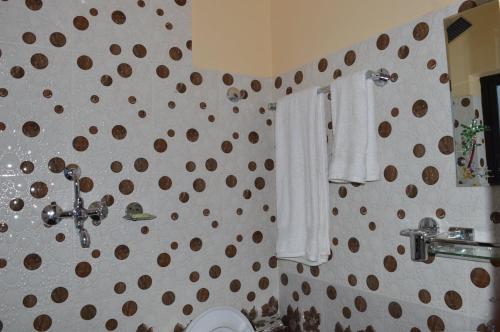 a bathroom with a toilet and towels on the wall at Panorama Guest House in Nagarkot
