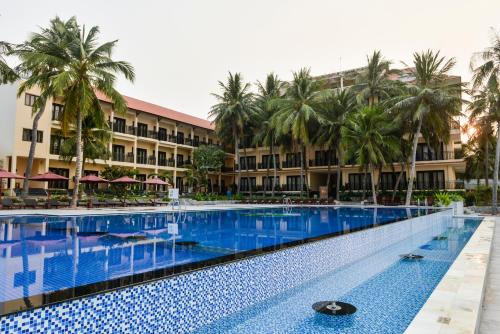 a large swimming pool in front of a resort at Hon Rom Central Beach Resort in Mui Ne