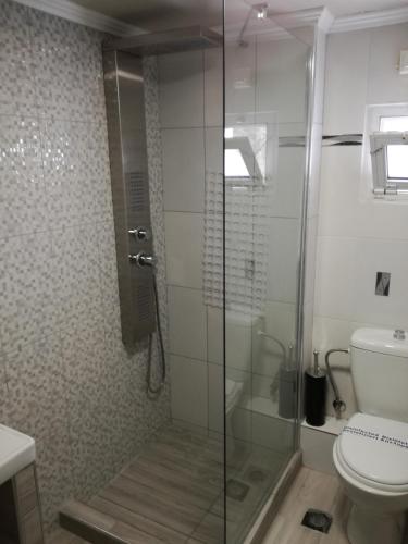 a bathroom with a glass shower with a toilet at Four Seasons Hotel in Trílofon