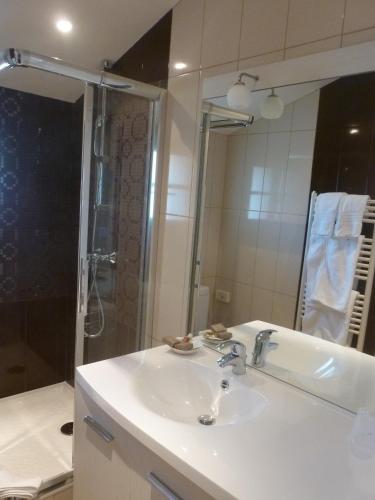 une salle de bain avec un lavabo blanc et une douche dans l'établissement Hotel Bel Air, à Saint-Jean-de-Luz