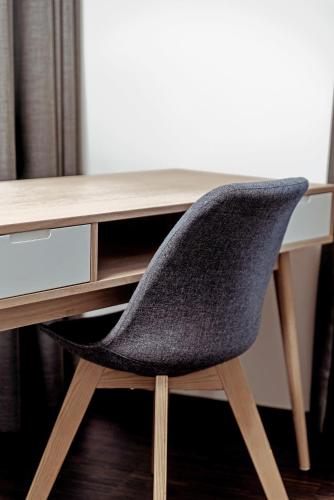 a chair sitting in front of a wooden desk at Vistay apartments in Luxembourg