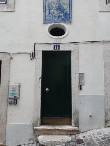 a green door on the side of a building at Bica Mini Hostel in Lisbon
