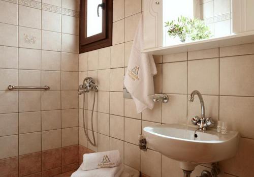 a bathroom with a sink and a toilet and a window at Archontiko Manias in Axós