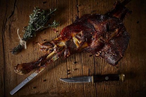 a piece of meat on a table with a knife at Archontiko Manias in Axós