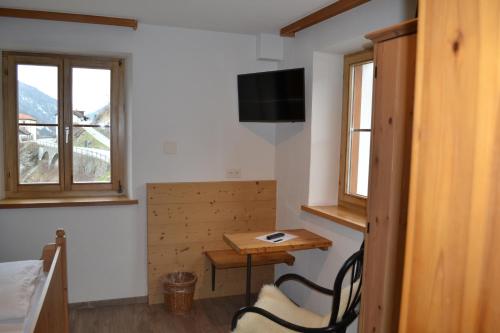 a room with a table and a small table and window at B&B Chasa Arfusch in Ardez