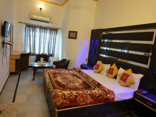 Hotel Taj Plaza, VIP Road, Agra في آغْرا: غرفة فندقية بسرير كبير وطاولة
