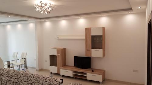 a living room with a couch and a tv on a wall at Sunrise Suites, Apt. 2 in Birkirkara