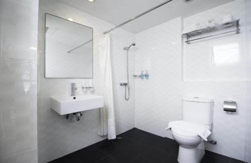 W łazience znajduje się toaleta, umywalka i prysznic. w obiekcie Harbour Ville Hotel w Singapurze