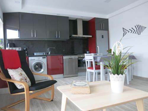 a kitchen with red cabinets and a table and chairs at Serena Beach 2 in Nazaré