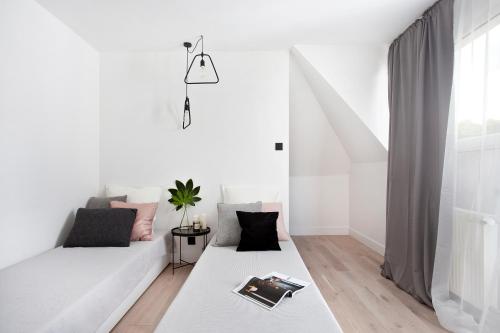 a white living room with a couch and a window at Sopot On the roof in Sopot