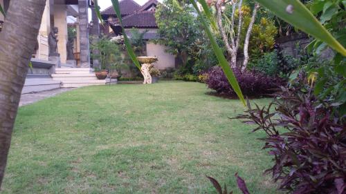 a garden with a bird bath in the middle of a yard at Murdhasari in Ubud
