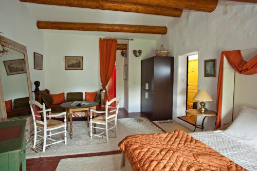 une chambre avec un lit, une table et des chaises dans l'établissement La Nesquière Chambres d'Hôtes, à Pernes-les-Fontaines