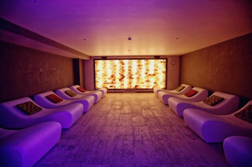 a row of purple chairs in a room with a window at Premium Beach Hotel in Golem