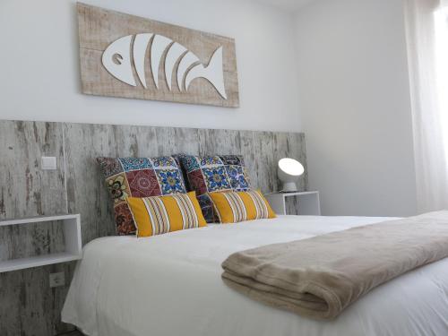 a bedroom with a white bed with colorful pillows at Serena Beach 2 in Nazaré