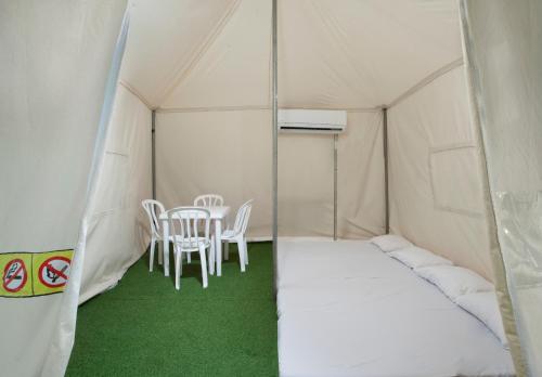 a tent with a table and chairs in it at The Camping Site Hamat Gader in Kinneret