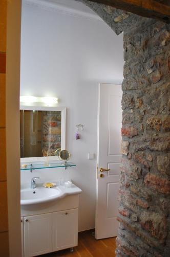 a bathroom with a sink and a stone wall at Villa "Pietra e Mare" in Nafpaktos