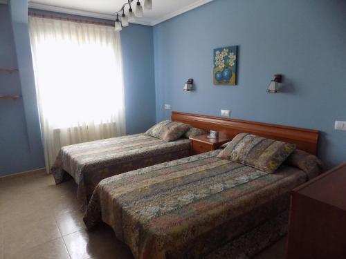 Apartamentos Las Llábanas في Oviñana: سريرين في غرفة بجدران زرقاء