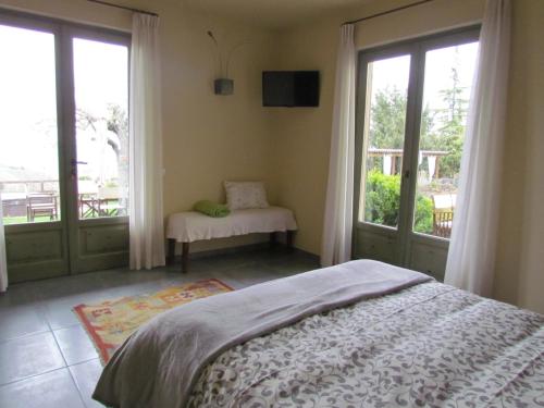 a bedroom with a bed and a balcony with windows at Casa Vacanze San Stefanetto in Treiso