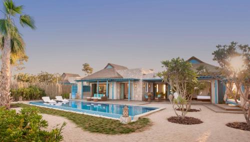 a villa with a swimming pool and a house at Banana Island Resort Doha by Anantara in Doha