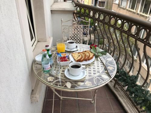 a table with a breakfast of coffee and croissants on a balcony at Art 'Otel in Sofia
