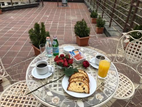 a table with a breakfast of bread and coffee and flowers at Art 'Otel in Sofia
