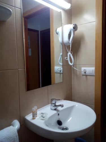 a bathroom with a white sink and a mirror at Hostal Residencia Nicolau in San Antonio