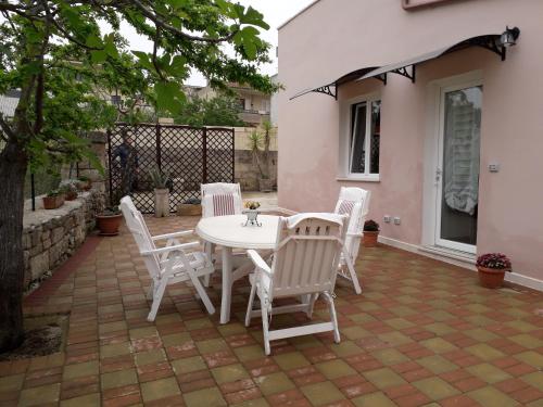 - une table et des chaises blanches sur la terrasse dans l'établissement Casa Vacanza Campoli, à Ruffano