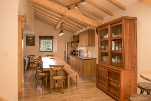 une cuisine avec une grande table et des chaises en bois dans l'établissement La Ferme du Nol, à La Bresse