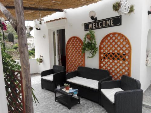 a patio with two couches and a welcome sign at La Necussella in Anacapri
