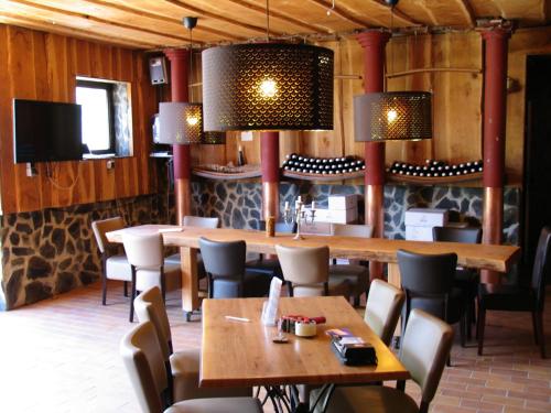 a restaurant with wooden tables and chairs and lights at Weingut Schumacher - mit privatem Saunabereich in Sankt Aldegund