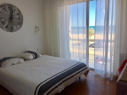 a bedroom with a bed and a clock on the wall at Bel appart vue mer in Valras-Plage