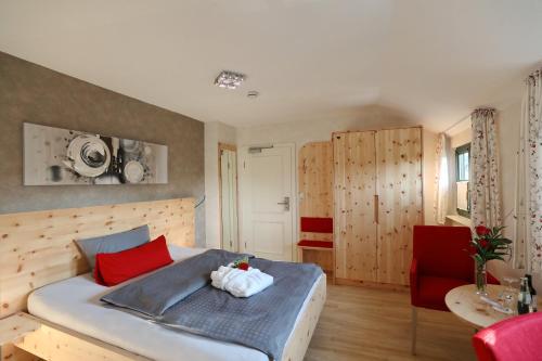 a bedroom with a bed with red and white towels on it at Landhotel Villa Moritz garni in Oberahr