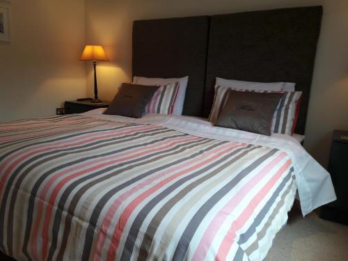 a bedroom with a large bed with a striped comforter at 6 The Net Loft in Mevagissey