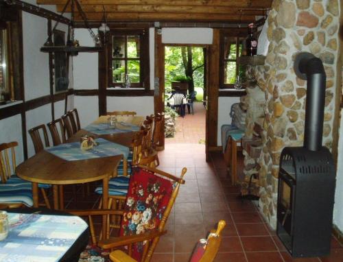 a restaurant with a fireplace and tables and chairs at Landhaus Burs in Löningen