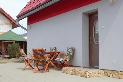 a patio with two chairs and a table next to a door at Petúnia-dom s dvoma spálňami in Bešeňová