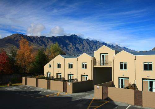 a row of buildings with mountains in the background at Queenstown Gateway Apartments in Queenstown