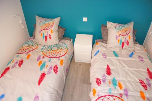 a bedroom with two twin beds and a blue wall at Vue sur l'art roman in Rosheim
