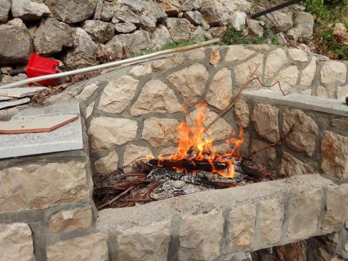 a fire burns in a stone fire pit at Holiday Home Free your mind in Dobra Voda