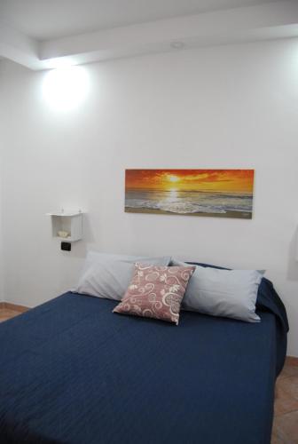 - une chambre avec un lit orné d'une peinture murale dans l'établissement Casa Rubino, à Cefalù