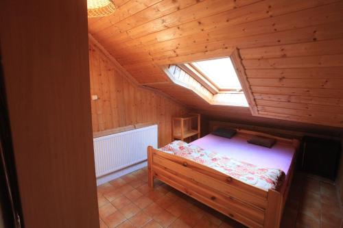 a bedroom with a bed in a wooden room with a window at Schronisko młodzieżowe w Jabłonkach in Jabłonki