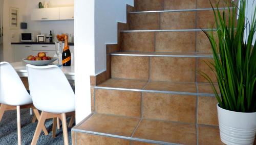 two views of a kitchen and a staircase with a plant at Ferienwohnung in Seewalchen in Seewalchen
