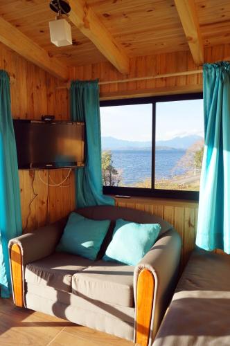a couch in a room with a large window at Cabañas Ranco Lauken in Lago Ranco