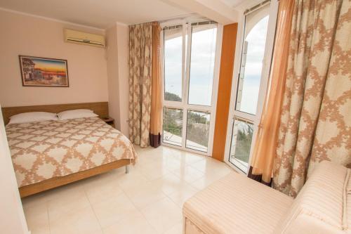 een slaapkamer met een bed en grote ramen bij Villa Del Mar in Sutomore