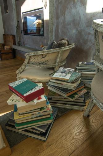 a pile of books sitting on the floor next to a chair at Agriturismo Treterre in Pianello Del Lario