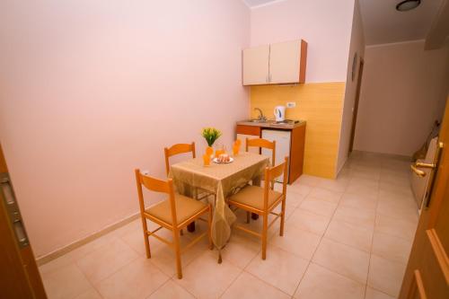 a kitchen with a table and chairs in a room at Villa Del Mar in Sutomore