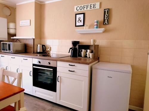 eine Küche mit weißen Schränken und einer Arbeitsplatte in der Unterkunft house46-1 in Hohen Neuendorf