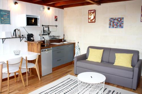 un salon avec un canapé et une cuisine dans l'établissement Le Grand-Victoire, Centre-Ville - Parking Gratuit, à Bordeaux