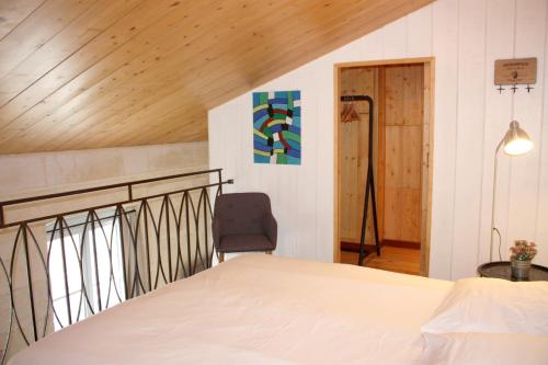 une chambre avec un lit et une chaise dans l'établissement Le Grand-Victoire, Centre-Ville - Parking Gratuit, à Bordeaux