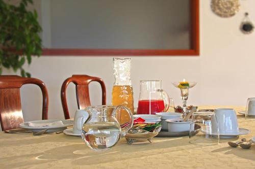 una mesa con platos y vasos encima en B&B La Betulla, en Rovereto