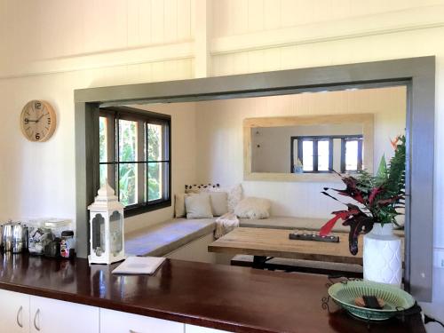 a large mirror in a living room with a couch at Daintree Magic Holiday House in Cow Bay